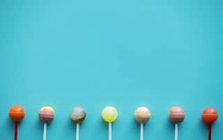 A group of lollipops isolated on an aqua background. It's a question that's beset many of us since we were kids - how many licks does it take to reach the center of a Tootsie Pop?