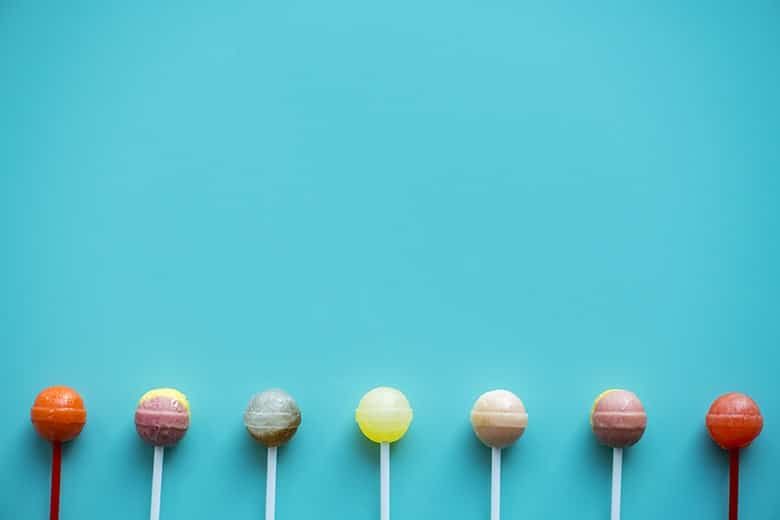 A group of lollipops isolated on an aqua background. It's a question that's beset many of us since we were kids - how many licks does it take to reach the center of a Tootsie Pop?