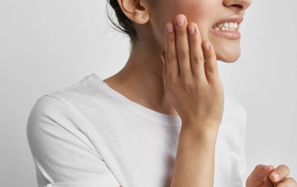 young adult woman holding her mouth in pain