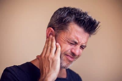 adult man holding his ear in pain