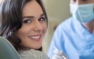 Woman smiling with dentist in the background