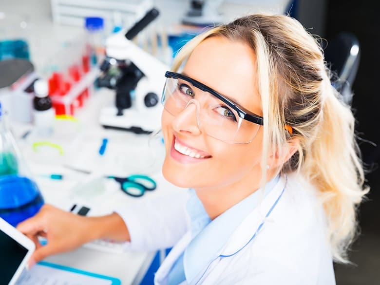 Young attractive woman scientist writing research report in the laboratory. She's used science to improve her outlook